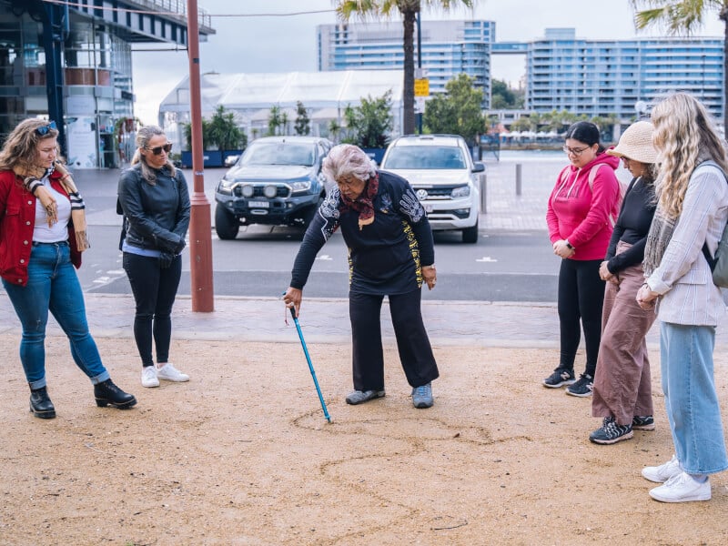 Aunty Margret draws the Eora Nation in the sand
